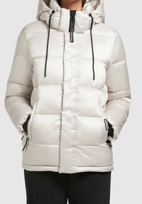 Chaqueta acolchada gris claro con capucha, que cuenta con una cremallera frontal, cordones negros y bolsillos laterales con cremalleras. Textura lisa y brillante.