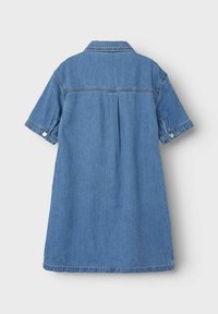 Robe en denim à manches courtes de couleur bleu moyen avec un col, des poignets boutonnés et une coupe ample, présentant des détails de pièces et de plis.