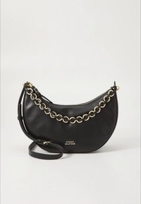 Črna usnjena torbica za čez ramo v obliki polmeseca, z zlato verižico na traku, zadrgo in reliefnim logotipom spredaj.