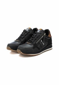 Zapatillas negras con parte superior de cuero liso y ante, que cuentan con una cremallera lateral, detalles en tono marrón y suela de goma. Detalle texturizado en el talón visible.