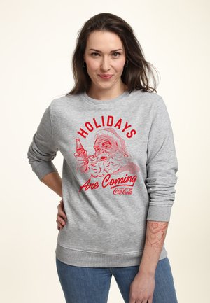 Grauer Sweatshirt mit einem roten Grafikmotiv von Santa, der eine Limonade hält, und dem Text "HOLIDAYS Are Coming" im Vintage-Stil. Material aus Baumwollmischung.