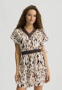Kurzärmliges Kleid in hellem Beige mit einem braunen Tiermuster. Verfügt über einen V-Ausschnitt und einen elastischen Bund für eine anpassbare Passform. Glatte Textur.