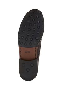 Semelle de chaussure en caoutchouc noir avec des motifs de grip circulaires, présentant des accents en cuir marron et un design de visage souriant au talon. Logo de la marque visible.