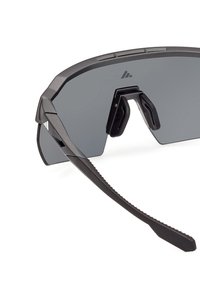 Ochelari de soare cu o ramă neagră mată, cu lentile mari și întunecate, design unghiular, cu pernuțe din cauciuc pentru nas și tejghele negre texturate.