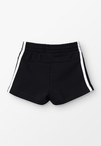 Mustat urheilushortsit, joissa on joustava vyötärö, ja valkoiset sivusuunnat. Valmistettu pehmeästä kankaasta, suunniteltu mukavuuteen ja liikkumiseen.