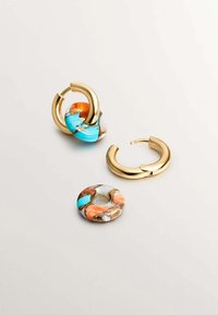 Pendientes de aro de oro combinados con piezas de resina en tonos turquesa, naranja y tierra, que muestran una textura brillante y formas circulares.
