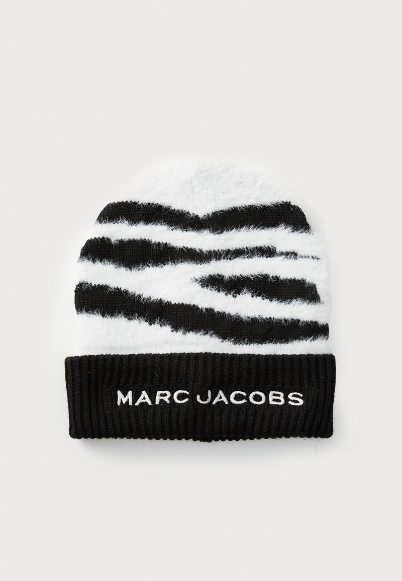 Svart och vit mössa med ett fluffigt zebramönster och en ribbad svart muddel som har "MARC JACOBS" broderat i vitt.