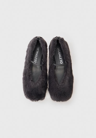 Dunkelgraue Slipper aus Kunstfell mit einer abgerundeten Zehe, elastischem Einstieg und Innenfutter aus Leder. Sie zeichnen sich durch ein minimalistisches Design ohne sichtbare Verzierungen aus.