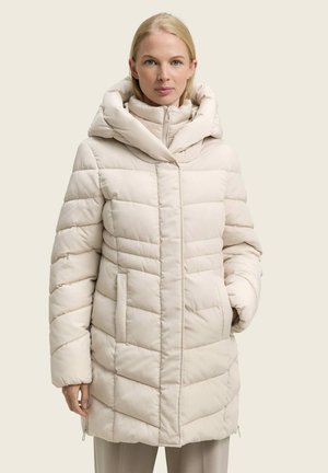 Doudoune beige clair, avec un col montant, une capuche, un motif matelassé diagonal, une fermeture éclair à l'avant et des poches latérales. Texture douce et lisse.
