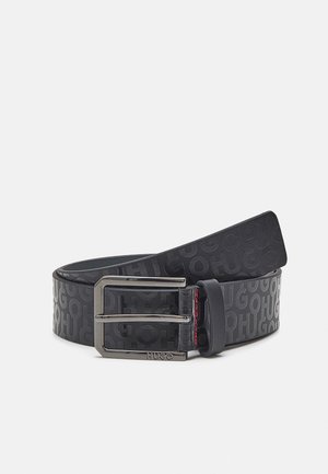 Ceinture en cuir noir avec un motif embossé "HUGO", boucle rectangulaire en métal argenté avec l'inscription gravée "HUGO" et surpiqûres rouges près de la boucle.