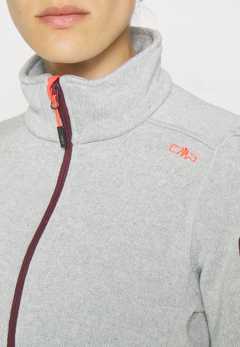 Grauer Fleece-Jacke mit hohem Kragen, ausgestattet mit einem dunkelroten Reißverschluss und einem leuchtend orangefarbenen Ziehband. Beinhaltet ein kleines Logo in Orange am Kragen.