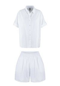 Weißes Kurzarmhemd mit Knopfleiste und umgeschlagenen Ärmeln, kombiniert mit passenden Shorts mit elastischem Bund. Leichter Stoff mit einer subtilen Textur.