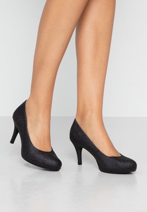 Mustat korkokengät, joissa on kimalteinen pinta, pyöreä kärki ja sileä rakenne. Varustettu keskikorkealla stilettokorkealla.