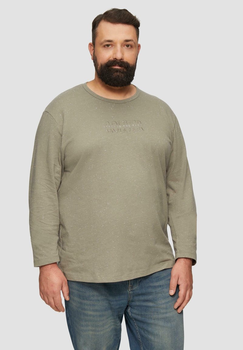 Langärmliges, olivgrünes Hemd aus weichem Stoff, mit einem strukturierten Frontdruck und Rundhalsausschnitt. Kombiniert mit Denim-Jeans.