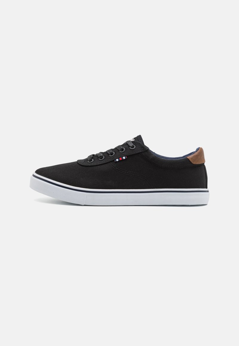 Black canvas sneaker with a white rubber sole, featuring black laces, a brown leather heel accent, and subtle striped detailing on the side.
