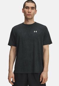 Mustmust must-shirt, mille tekstuuriga mustri, lühikeste varrukate, ümmarguse kaelusega ja väikese valge logoga vasakul rinnal.