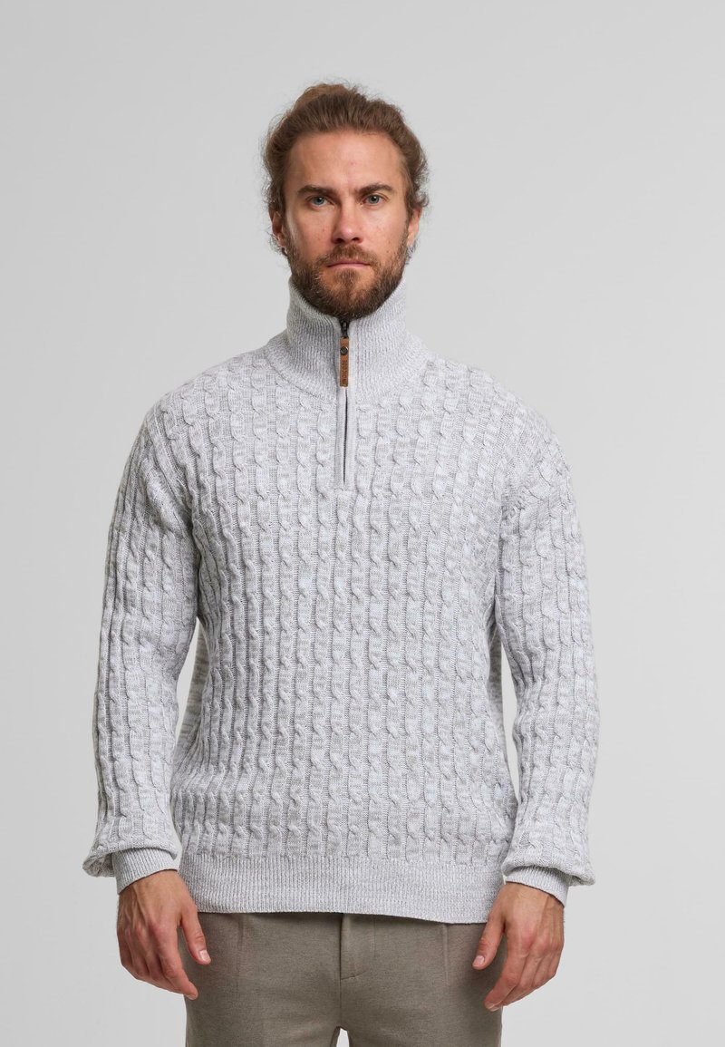 Pull en tricot gris clair avec un col haut et une fermeture éclair demi-zippée. Doté d'un motif en câble texturé et de poignets et d'un ourlet côtelés.