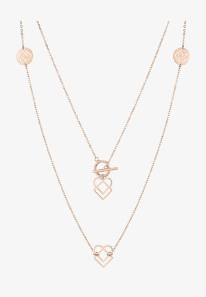 Collier à double couche en or rose présentant deux pendentifs en forme de cœur liés et un fermoir à bascule ; chaînes délicates avec des accents ronds portant le logo.