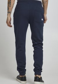 Dunkelblaues Sweatpant aus Baumwollmischung, mit schmaler Passform, elastischem Bund und einer einzelnen Gesäßtasche mit Etikett.