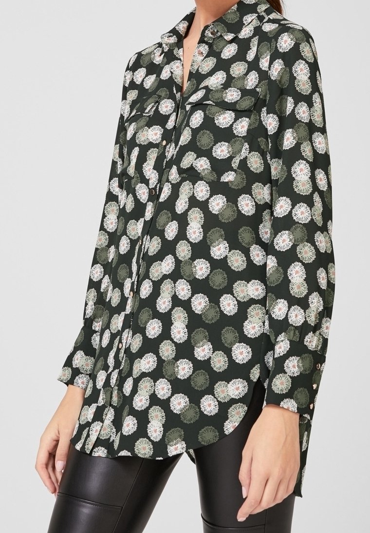 Camicia a maniche lunghe realizzata in tessuto leggero di colore verde scuro con motivo floreale, dotata di due taschini sul petto e polsini abbottonati.
