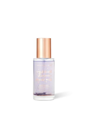 Przezroczysta szklana butelka z różowo-złotą nakrętką zawierająca fioletowy mist do twarzy oznaczony jako „Crystallove Crystallized Shimmer Facial Mist, wygładzający i przeciw niedoskonałościom."