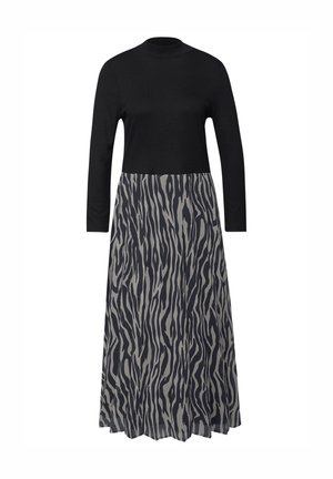 Schwarzes, langärmeliges Oberteil mit hohem Kragen und fließendem grauem Rock mit schwarzem, abstraktem Zebra-ähnlichem Muster.