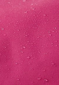 Wodoodporny różowy materiał o teksturowanej powierzchni, prezentujący krople wody. Materiał wydaje się być trwały i mocno tkany.