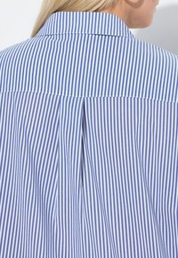 Koszula w niebiesko-białe paski z klasycznym kołnierzykiem, z tylną zaszewką i gładką fakturą tkaniny.