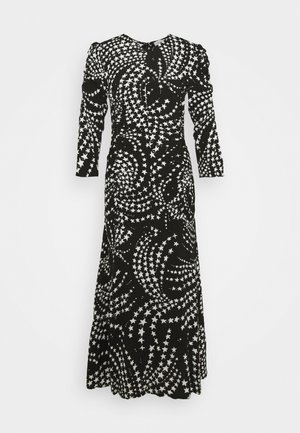 Robe noire à manches longues avec un motif en spirale d'étoiles blanches. Fabriquée en tissu doux, avec une coupe décontractée et une jupe jusqu'au sol.