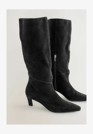 Schwarze kniehohe Stiefel aus Wildleder mit spitzer Zehenpartie und niedrigem Blockabsatz. Verfügen über einen seitlichen Reißverschluss und dezente Nahtdetails.