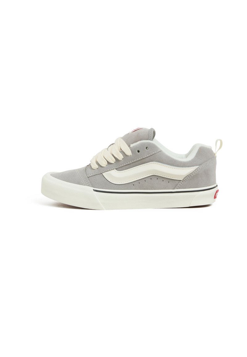 Sneaker basse in suede grigio con lacci crema, striscia laterale bianca e dettagli neri, dotata di perforazioni per la traspirazione e suola in gomma.