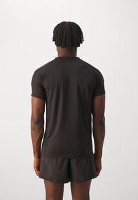 Puma EVOSTRIPE - Jednoduché tričko - puma black