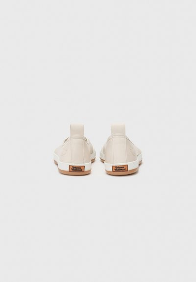 Beige Leinenschuhe mit einer glatten Textur, elastischen Seitenpanelen und Gummisohlen. Sie verfügen über ein kleines Logo und ein Markenetikett an der Ferse.