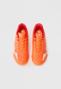 Baskets de sport orange vif avec une texture lisse, des accents rouges, un logo blanc et des lacets. Présentant un ajustement ajusté et un dessus à motif.