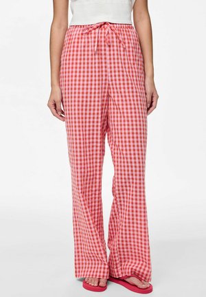 Pantalones de cuadros rojos y rosas con un diseño de pierna ancha. Cintura con cordón y textura suave. Combinados con chanclas rosas.