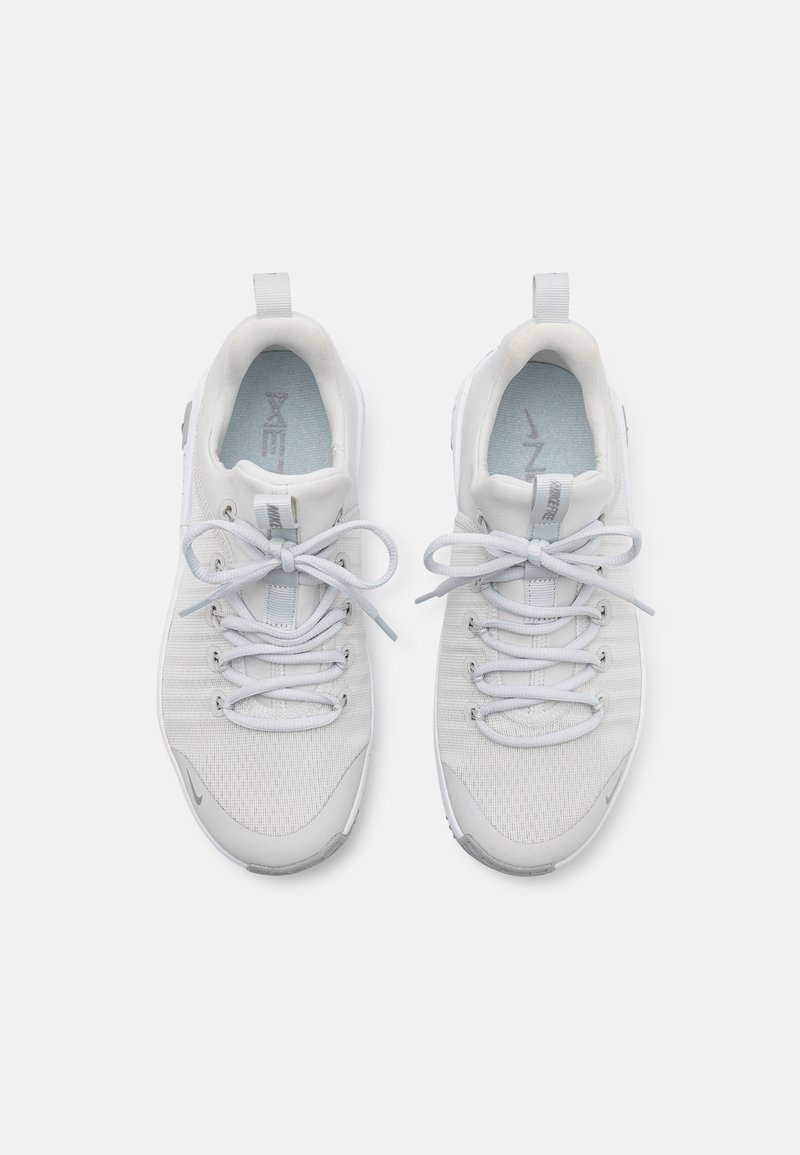 Scarpe sportive grigio chiaro con tomaia in mesh, punta rotonda, lacci e linguetta, caratterizzate da un branding discreto e dettagli testurizzati sulla suola.