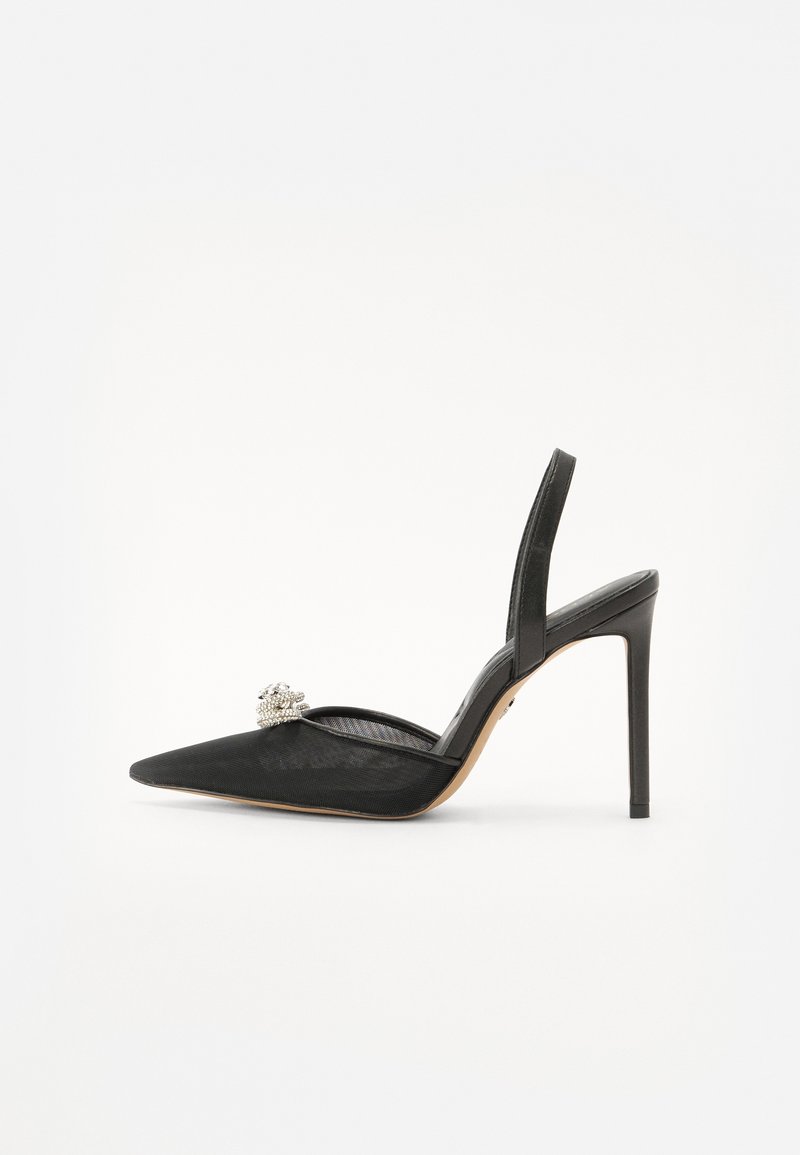 Escarpin noir à talon haut avec un bout pointu, en tissu en maille, et un ornement décoratif en argent sur le dessus.