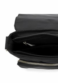 Czarna torebka na ramię z zamkiem błyskawicznym, gładką fakturą, wieloma wewnętrznymi przegródkami oraz złotym akcentem na zamku. Przestronny i funkcjonalny design.