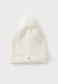 Witte gebreide beanie met een gestructureerd ontwerp, voorzien van een fluffy pompon bovenop en een gouden logo-accent aan de voorkant.