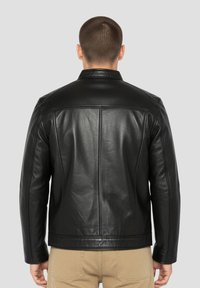 Zwarte leren jas met rechte snit, minimalistisch ontwerp en gedetailleerde stiksels zichtbaar over de schouders en rug.