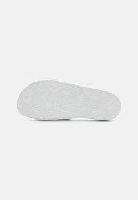 White sneaker sole with geometric hexagonal pattern, textured for grip, rounded toe, and flat design, made of rubber material.