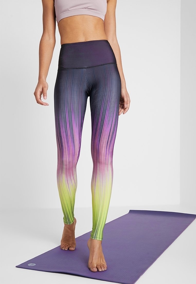 Legginsy z wysokim stanem w gradientowy wzór, przechodzący od ciemnego fioletu do zieleni. Z pionowymi paskami dla tekstury.