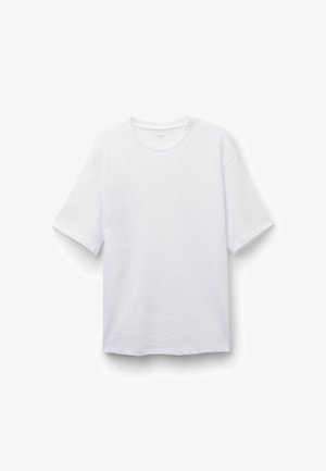 Biała koszulka z krótkim rękawem i okrągłym dekoltem, o luźnym kroju, prezentowana na jednolitym białym tle.