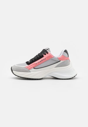 Zapatilla deportiva en gris claro, rosa y blanco, con cordones negros, suela gruesa y ondulada, y la marca "PINKO" en el panel lateral rosa.