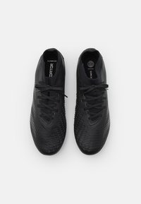 Scarpe da ginnastica nere con una tomaia texturizzata, caratterizzate da un design in rete, lacci tonali, solette con marchio e una forma della punta arrotondata.