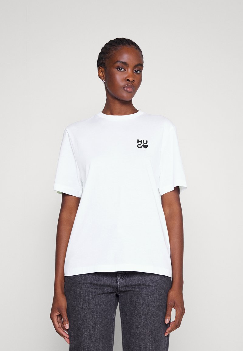 Valge puuvillane t-särk lühikeste varrukatega, mille vasakul rinnal on must "HUG" logo. Esteetiline lõikega ja ümar kaelus.