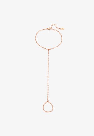 Roségoldene Handkette mit verbundenen Perlen, die das Armband am Handgelenk mit einem Ring am Finger verbindet, getragen auf einem hellen Ärmels.