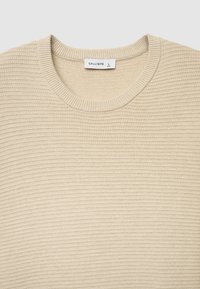 Maglione beige lavorato a maglia con texture coste e scollo rotondo. Etichetta con scritto "CALLIOPE", taglia L.
