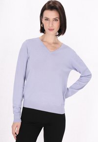 Jasnofioletowy sweter z dzianiny z dekoltem w serek, długimi rękawami i prążkowanym wykończeniem. Gładka struktura materiału oraz dopasowany krój.