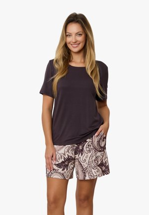 Ciemnofioletowa koszula z krótkim rękawem w połączeniu z jasnobeżowymi szortami, z misternym bordowym wzorem liści i zawijasów.